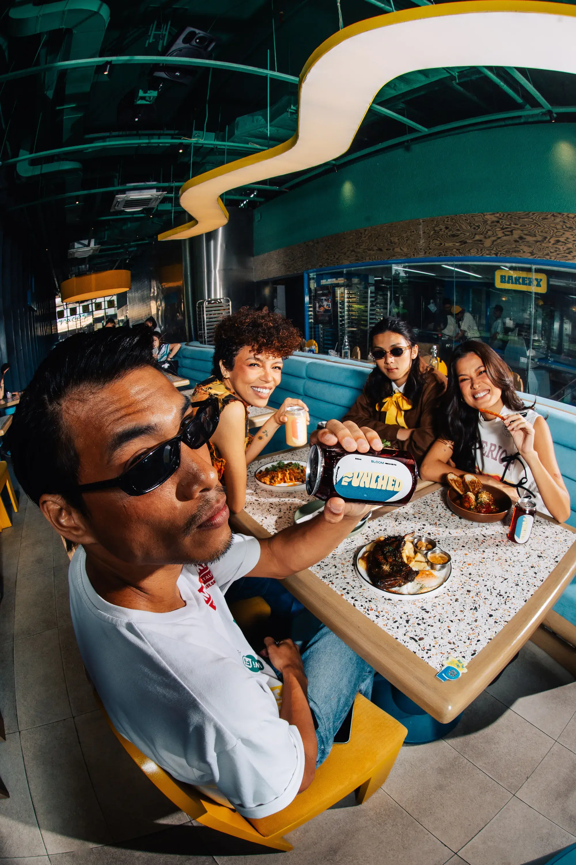 Friends at a table under the café’s wave ceiling, shot fisheye